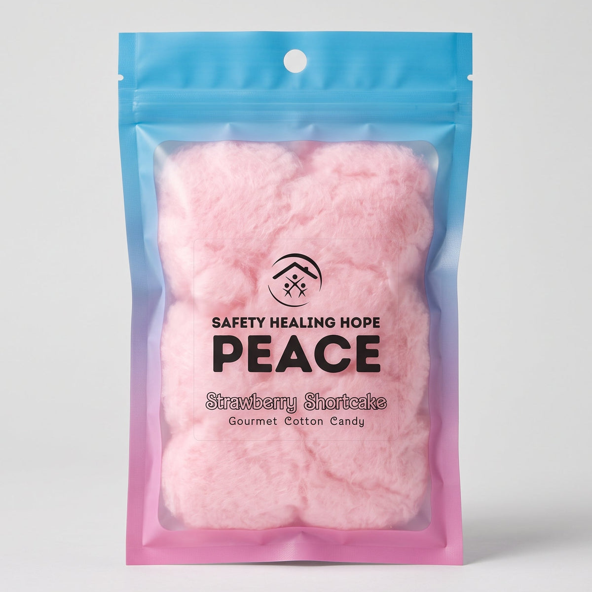 A stand-up pouch of pink strawberry shortcake gourmet cotton candy, featuring a blue-to-pink gradient bag with the brand name 'SAFETY HEALING HOPE PEACE' printed on the front, set against a light gray background.